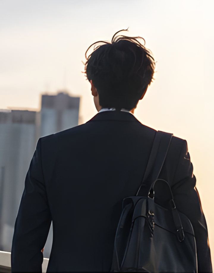 夕方の街を眺める男性の後ろ姿