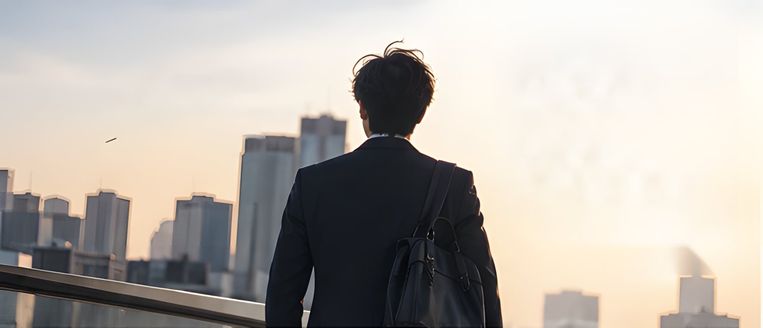 夕方の街を眺める男性の後ろ姿